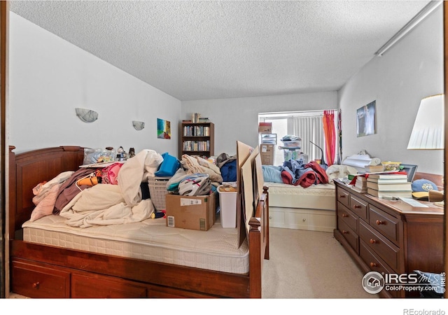 bedroom with light carpet and a textured ceiling