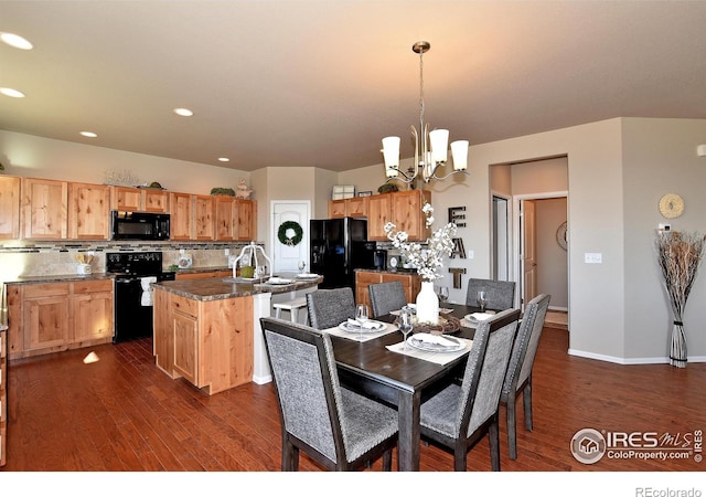 dining space with sink, dark hardwood / wood-style floors, and a notable chandelier