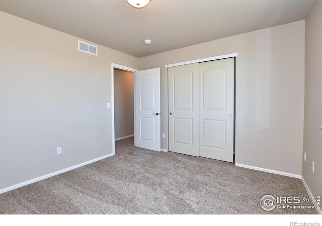 unfurnished bedroom featuring carpet flooring and a closet