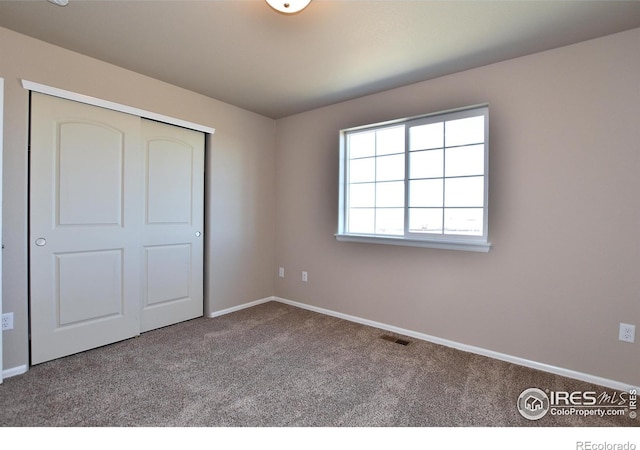 unfurnished bedroom with a closet and carpet floors