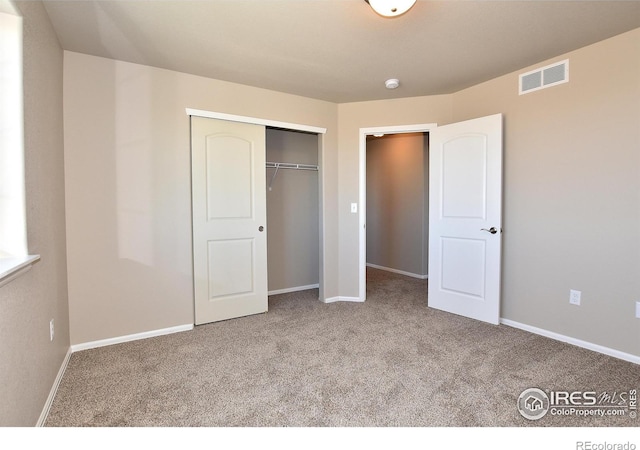 unfurnished bedroom with carpet and a closet