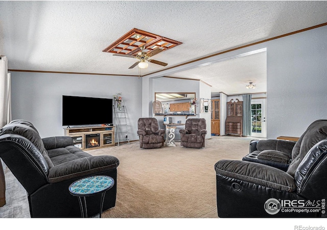 living room with carpet flooring, ceiling fan, ornamental molding, and a textured ceiling