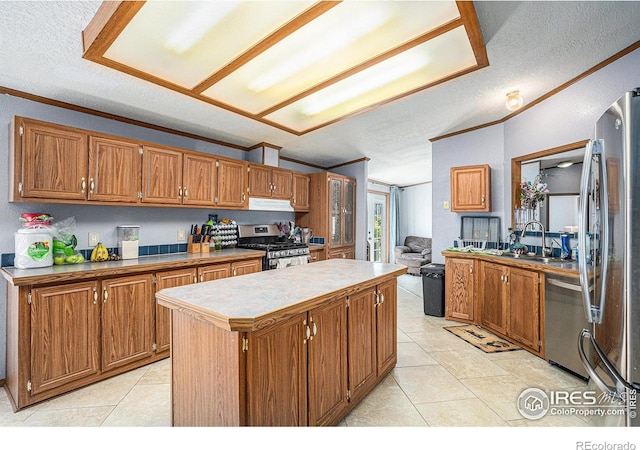 kitchen with appliances with stainless steel finishes, crown molding, sink, a center island, and light tile patterned flooring