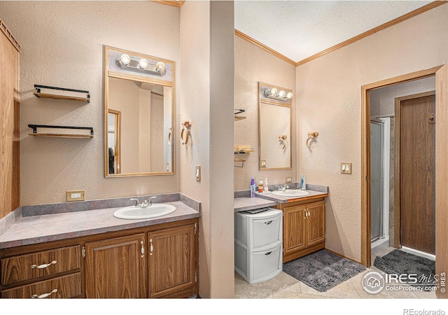 bathroom with vanity, tile patterned floors, crown molding, walk in shower, and a textured ceiling