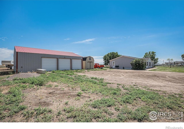 exterior space with a garage and an outbuilding