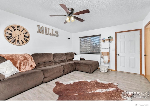 living room featuring ceiling fan, a textured ceiling, and light hardwood / wood-style flooring