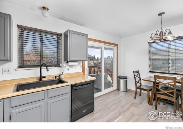 kitchen with sink, a chandelier, black dishwasher, gray cabinets, and hanging light fixtures