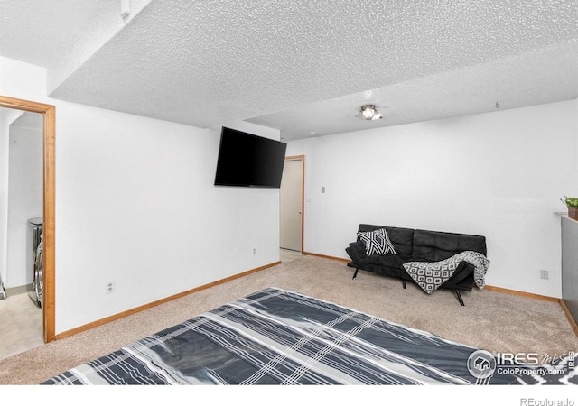 bedroom with a textured ceiling and light colored carpet