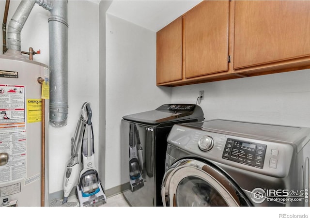 laundry room featuring cabinets, independent washer and dryer, and gas water heater