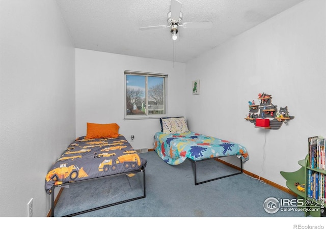 carpeted bedroom featuring ceiling fan and a textured ceiling