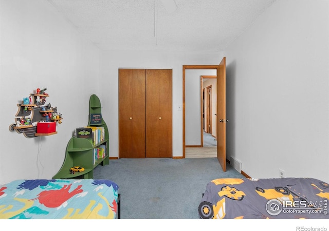 carpeted bedroom with a closet and a textured ceiling