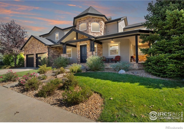 view of front of home featuring a garage, a porch, and a yard