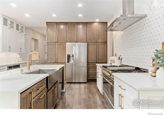 kitchen featuring appliances with stainless steel finishes, white cabinetry, sink, and wall chimney exhaust hood