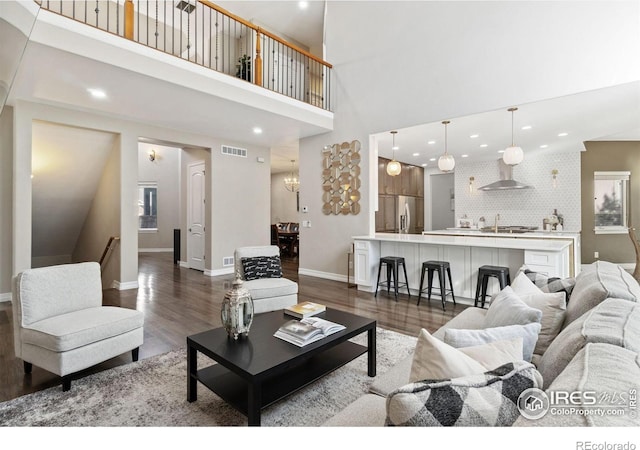 living room featuring a high ceiling and dark wood-type flooring