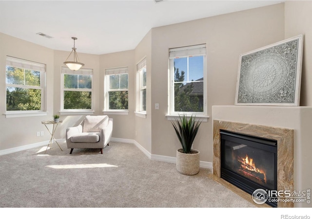 sitting room featuring a fireplace, light carpet, and a wealth of natural light