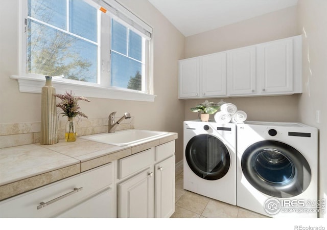 laundry room with sink, a healthy amount of sunlight, cabinets, and washer and dryer