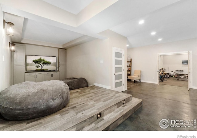 living room with concrete floors and a tray ceiling