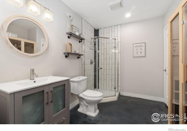 bathroom with toilet, vanity, and a shower with shower door