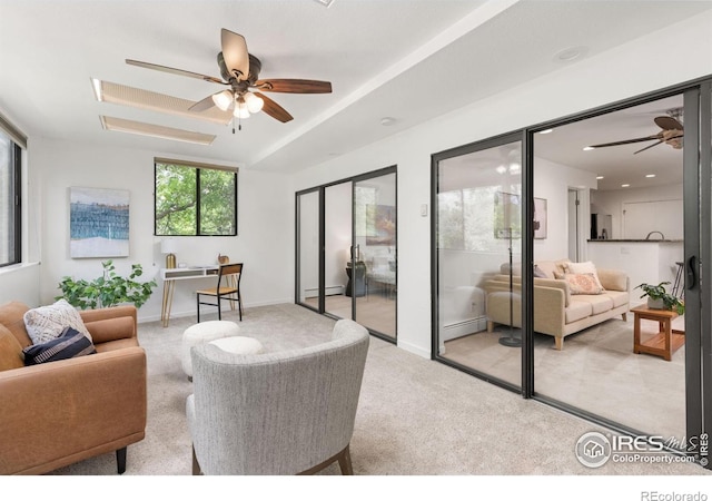 carpeted living room featuring a baseboard heating unit and ceiling fan