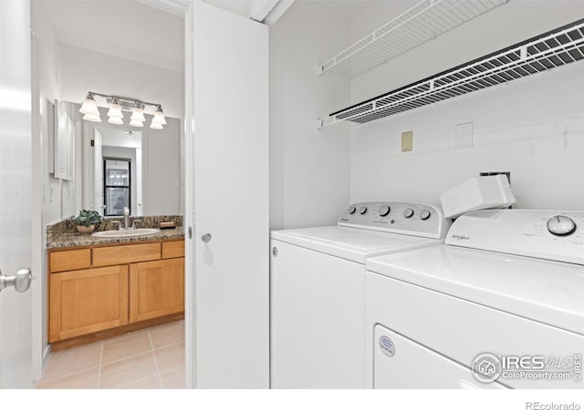 laundry room with sink, washing machine and dryer, and light tile patterned flooring