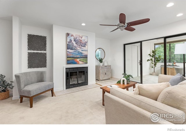 carpeted living room featuring a fireplace and ceiling fan