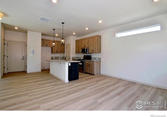 kitchen featuring a kitchen island with sink, hanging light fixtures, light hardwood / wood-style flooring, appliances with stainless steel finishes, and light stone counters