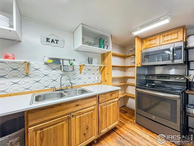 kitchen featuring tasteful backsplash, sink, stainless steel appliances, and light hardwood / wood-style flooring