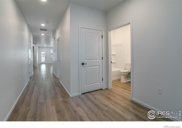 hallway with light hardwood / wood-style floors