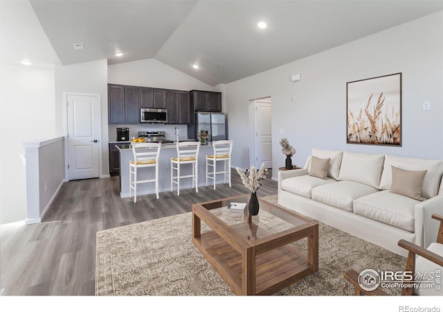 living room with hardwood / wood-style flooring and vaulted ceiling