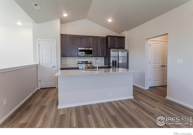 kitchen with sink, stainless steel appliances, hardwood / wood-style floors, a center island with sink, and dark brown cabinets