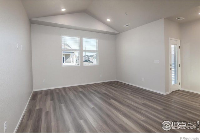 unfurnished room featuring dark hardwood / wood-style floors and vaulted ceiling