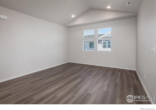 spare room with vaulted ceiling and dark wood-type flooring