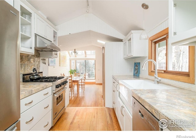 kitchen with appliances with stainless steel finishes, pendant lighting, white cabinets, and light stone counters