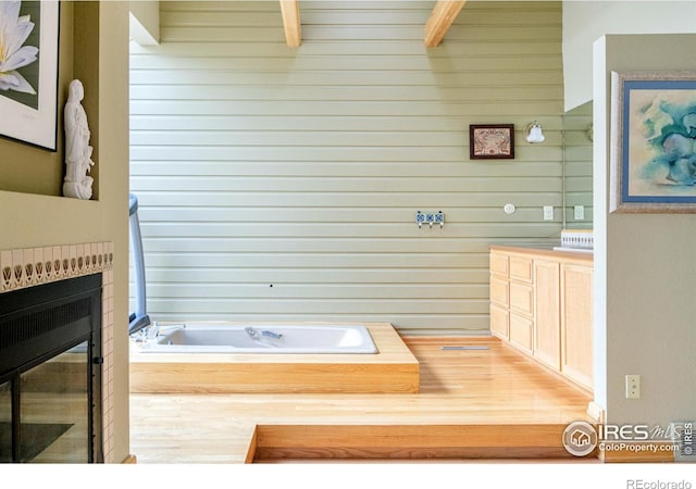 bathroom featuring a bathing tub and beamed ceiling