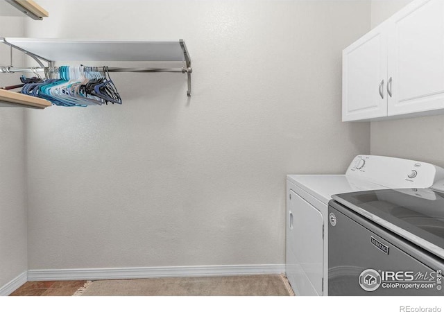 laundry room featuring cabinet space, baseboards, and washer and dryer