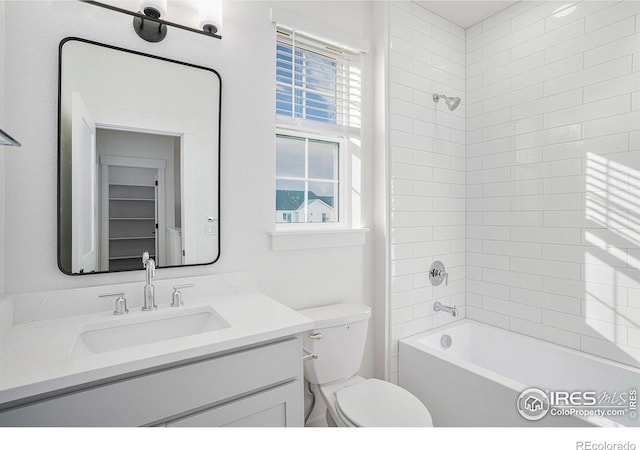 full bathroom with tiled shower / bath combo, vanity, and toilet