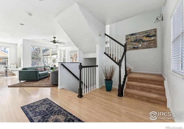 stairs with ceiling fan and wood-type flooring