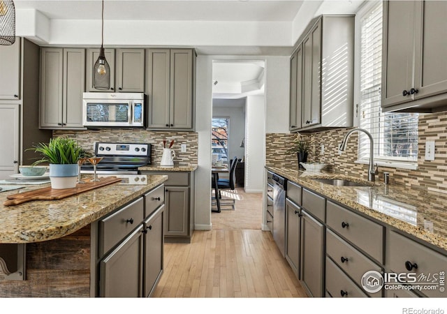 kitchen with stainless steel appliances, gray cabinetry, and sink