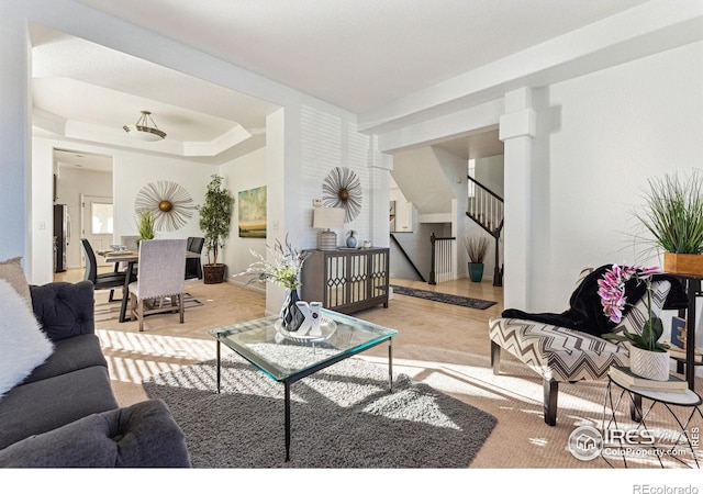 living room featuring light carpet and a tray ceiling