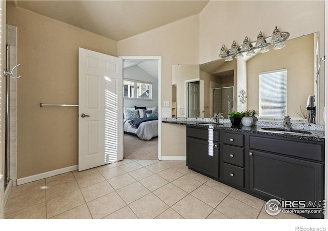 bathroom featuring tile patterned flooring, vanity, a shower with shower door, and vaulted ceiling