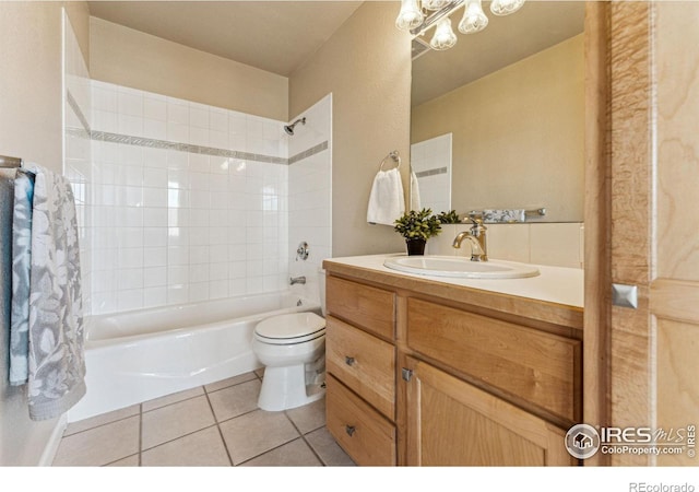 full bathroom with tile patterned floors, vanity, tiled shower / bath combo, and toilet