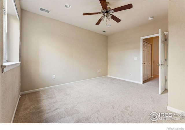 carpeted spare room featuring ceiling fan