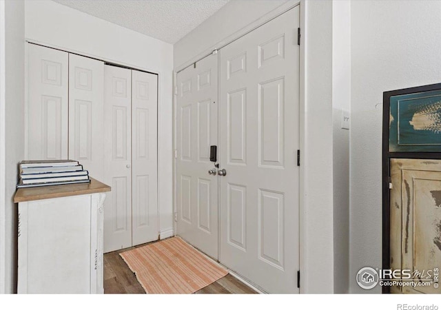 interior space with a textured ceiling and hardwood / wood-style flooring