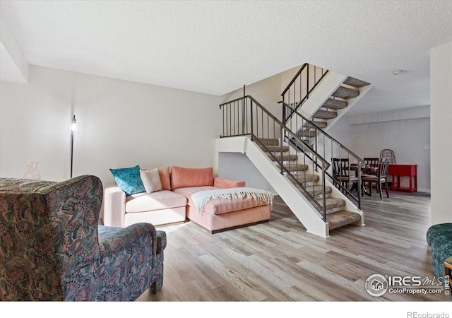 living room featuring a textured ceiling and light wood-type flooring