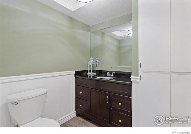 bathroom with vanity, a textured ceiling, and toilet