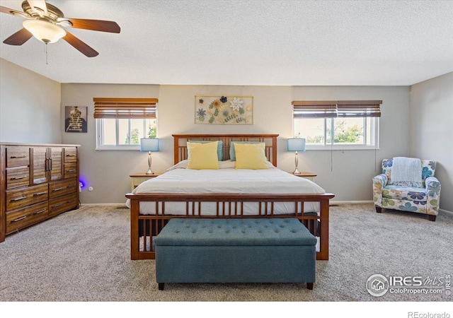 carpeted bedroom with a textured ceiling and ceiling fan