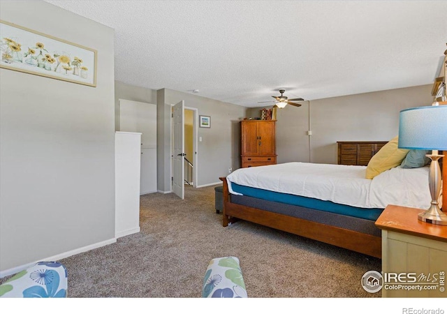 carpeted bedroom with ceiling fan and a textured ceiling