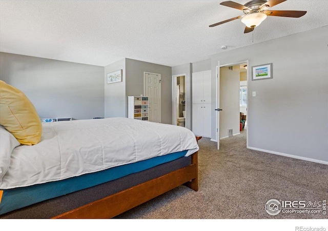 bedroom featuring carpet flooring, ceiling fan, ensuite bathroom, and a textured ceiling