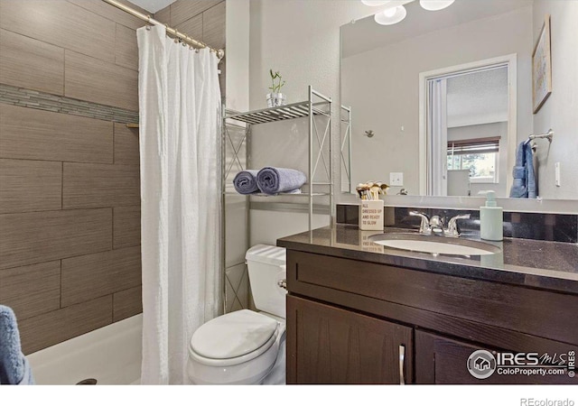 bathroom featuring a shower with curtain, toilet, and vanity