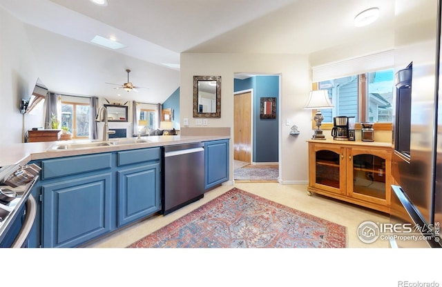 kitchen with blue cabinetry, ceiling fan, sink, vaulted ceiling, and appliances with stainless steel finishes